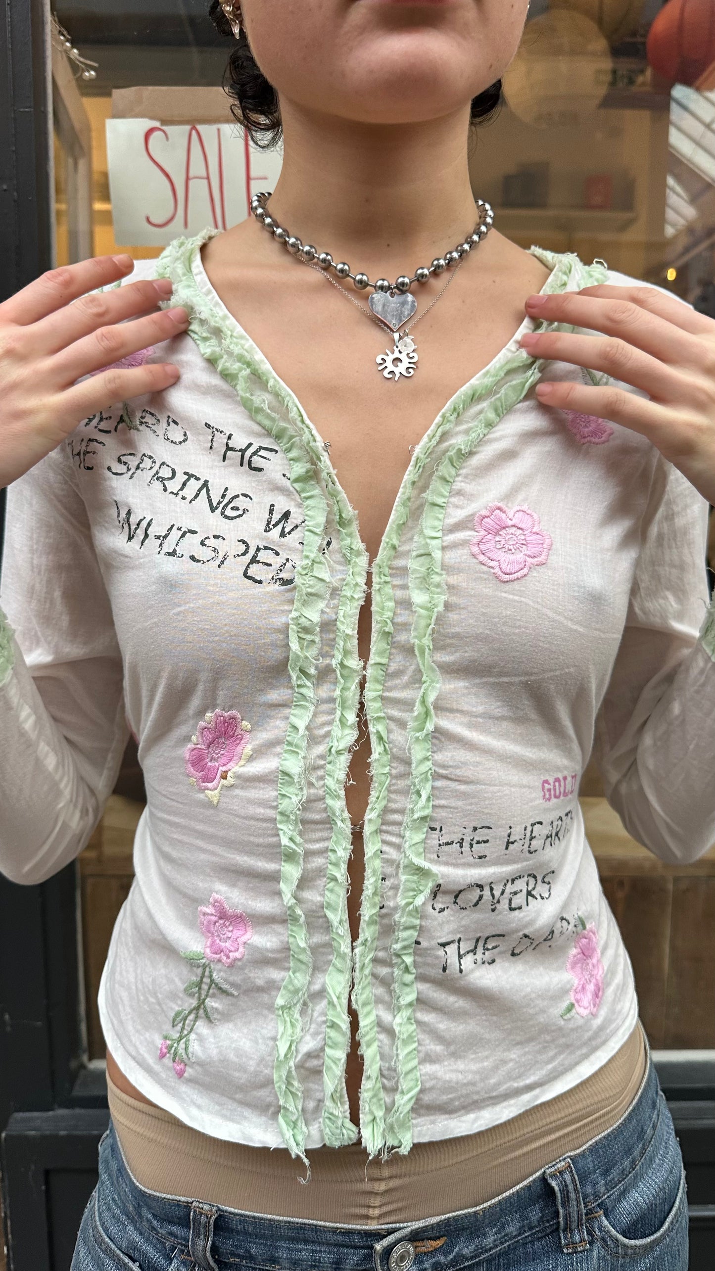 white cotton graphic pink flower and writing top labelled S